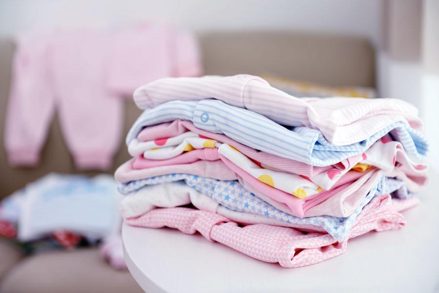 organizing baby clothes into piles